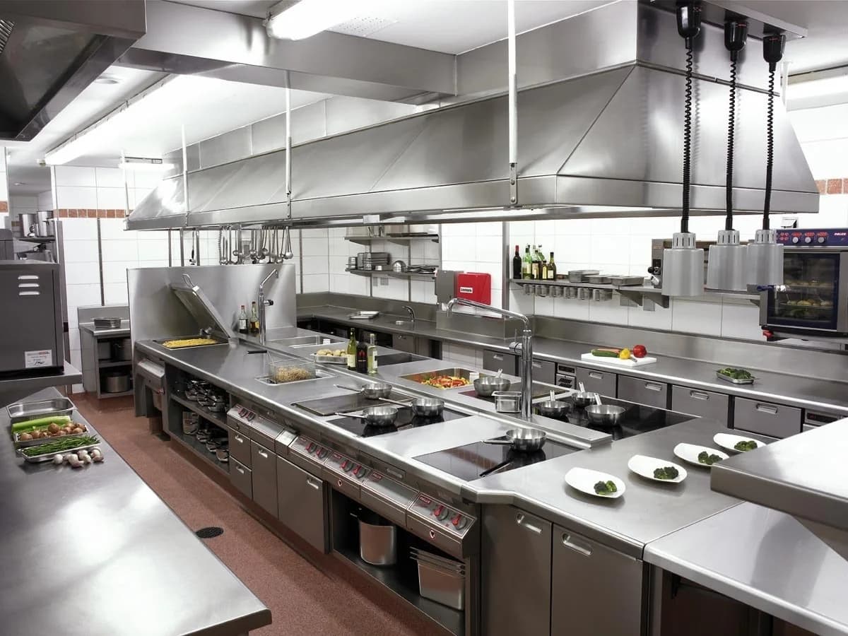 Full commercial kitchen with ranges, ovens and stainless prep equipment