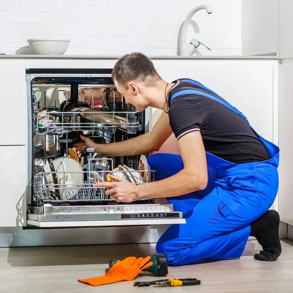 Technician repairing an open dishwasher