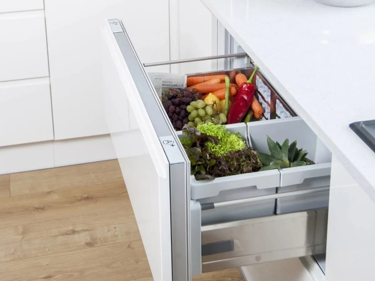 Open undercounter refrigeration drawer stocked with produce
