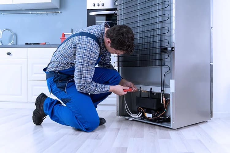 Technician repairing the rear panel of a refrigerator